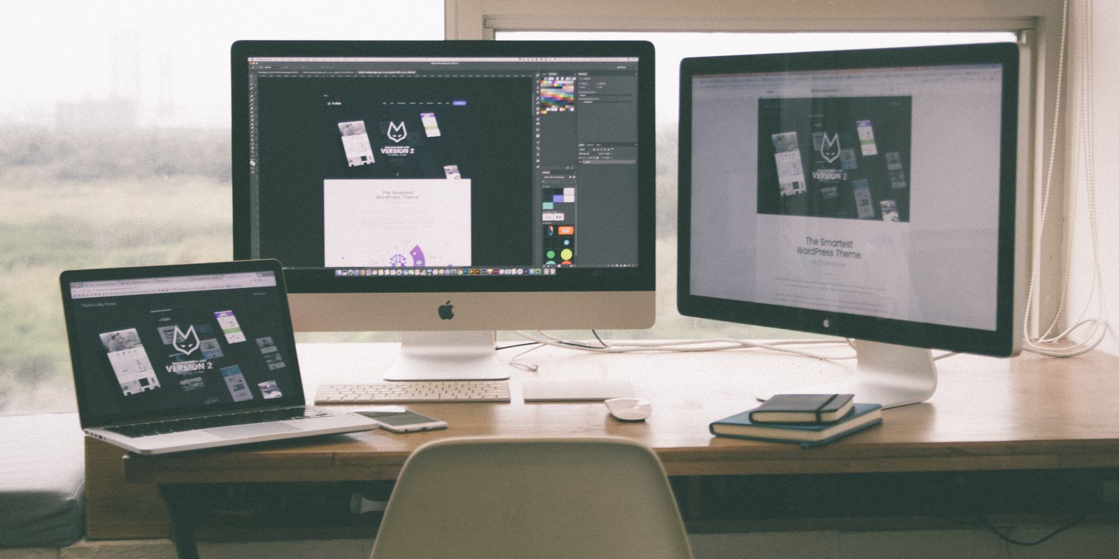Arbeidsstasjon med skjermer som viser nettsidedesign